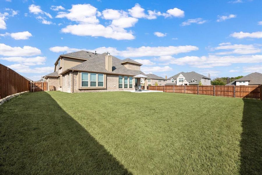 Back of house featuring a patio area and a big enclosed backyard