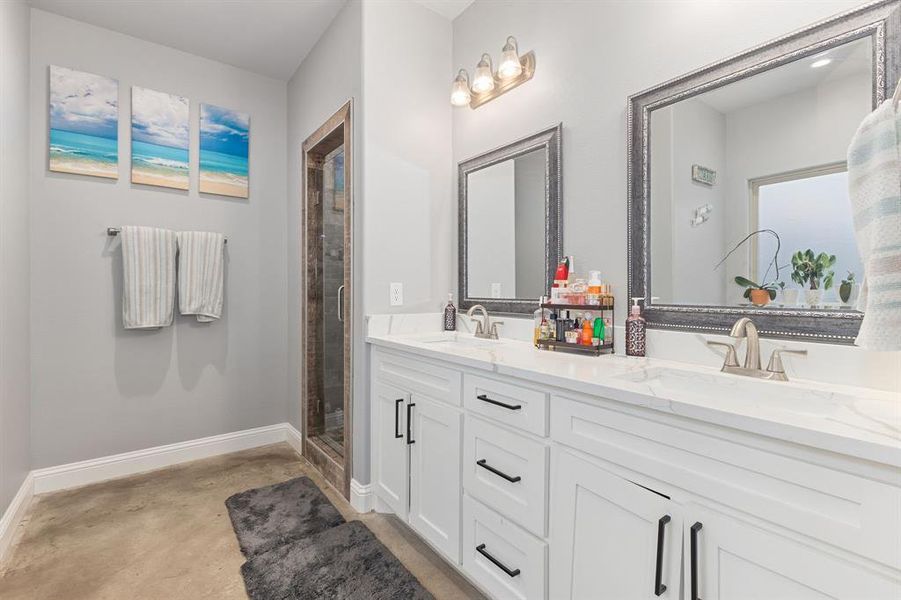 Bathroom featuring vanity, an enclosed shower, and concrete floors