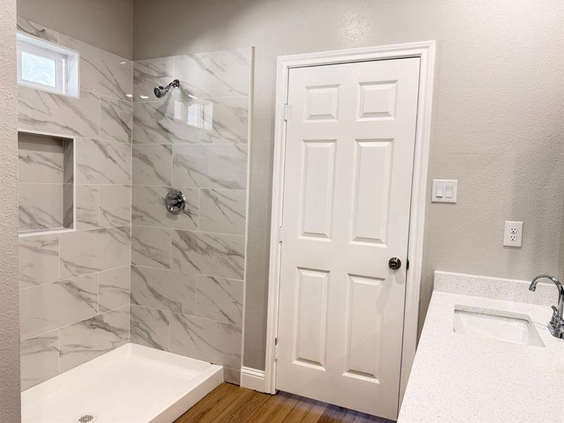 Bathroom with vanity, a shower stall, and dark wood-style flooring Bathroom with vanity, a shower stall, and dark wood-style flooring