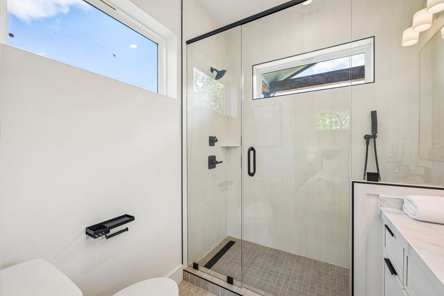 This beautiful bathroom features a spacious glass-enclosed shower and abundant natural light. This beautiful bathroom features a spacious glass-enclosed shower and abundant natural light.