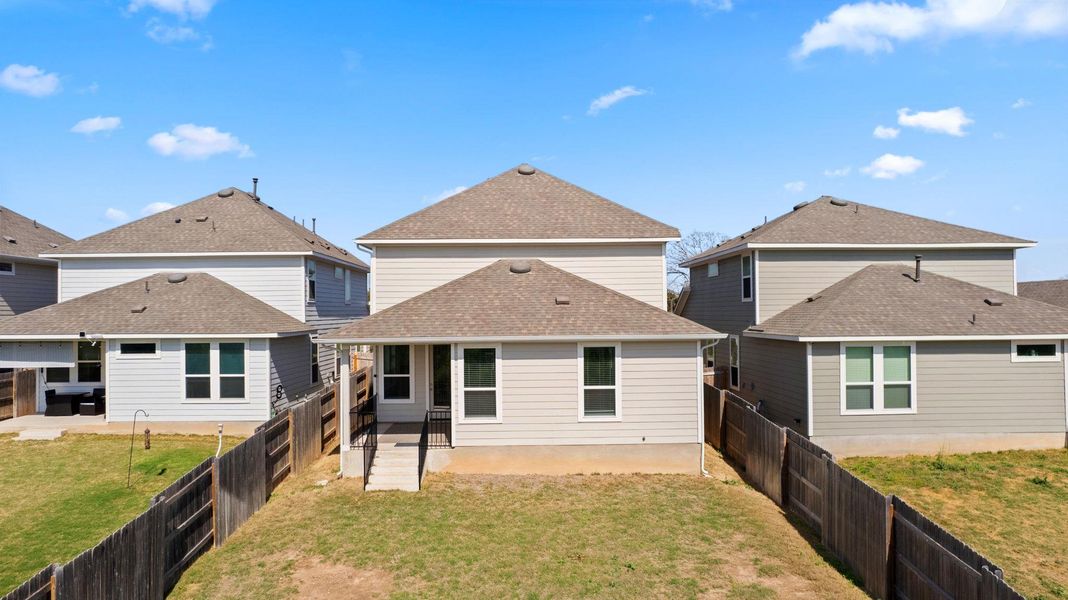 Back of house featuring a patio, a shingled roof, a fenced backyard, and a yard Back of house featuring a patio, a shingled roof, a fenced backyard, and a yard