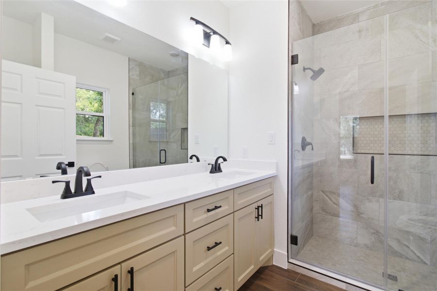Dual vanity with pristine white countertops and a sleek glass-enclosed shower create a tranquil retreat. Dual vanity with pristine white countertops and a sleek glass-enclosed shower create a tranquil retreat.
