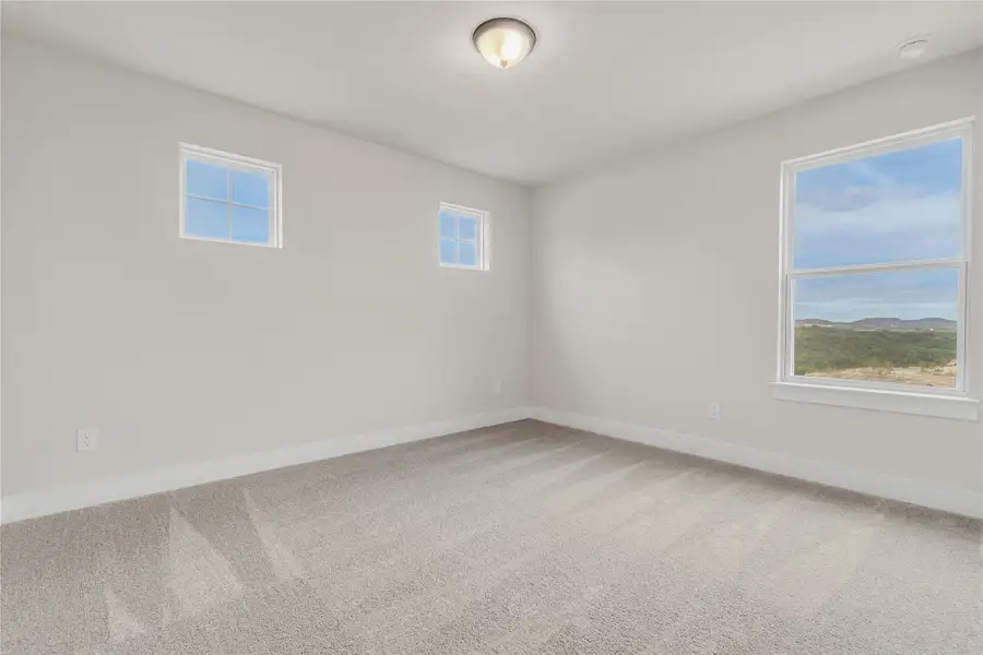 A quiet space with large windows offers serene views of distant hills.