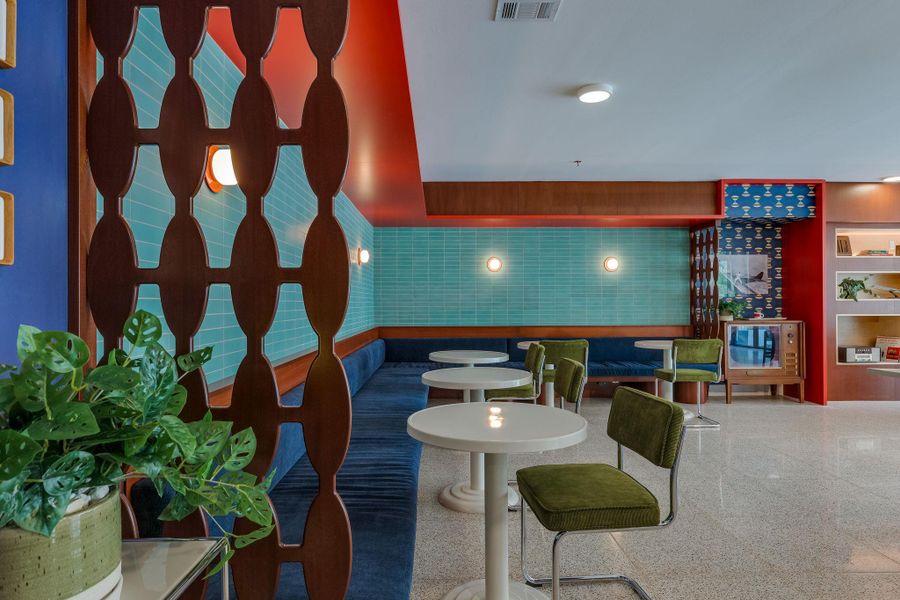 Lounge area featuring a long upholstered banquette, a decorative wood room divider, and accent lighting