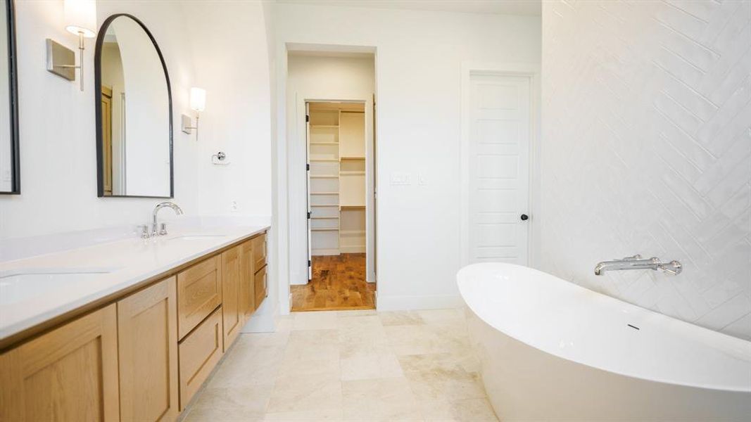 Bathroom with wood-type flooring, vanity, and a bath