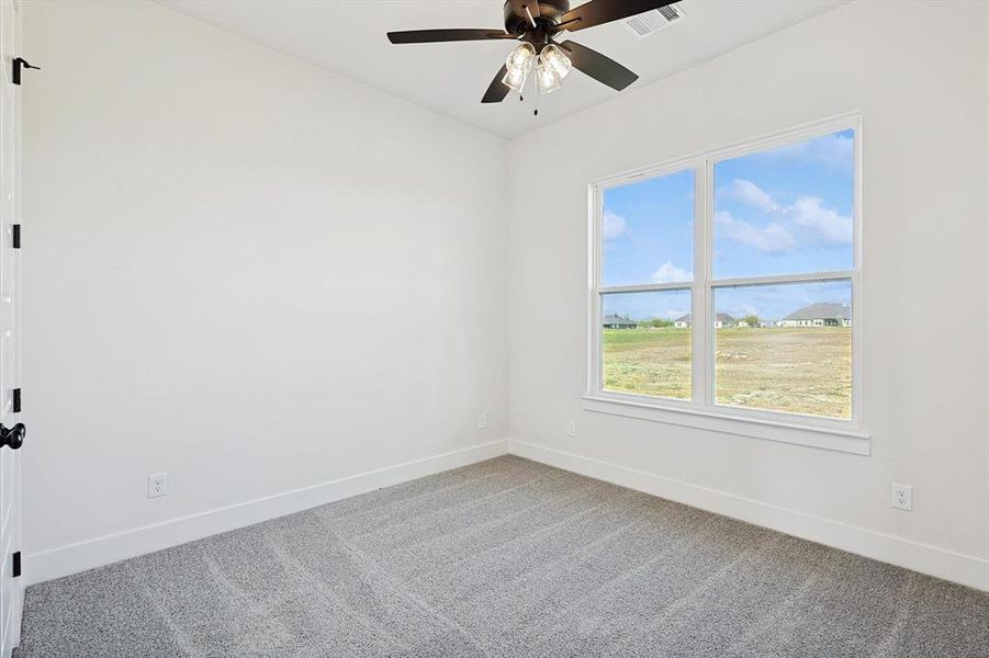 Carpeted empty room with ceiling fan