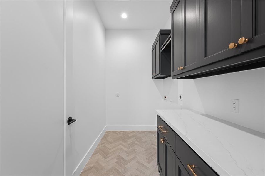 Laundry with quartz counters and herringbone tile