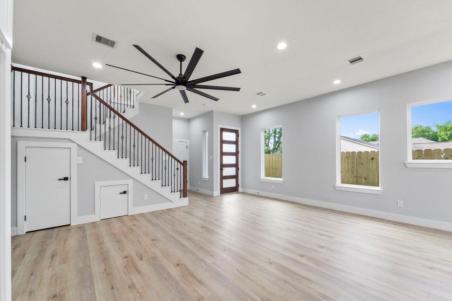 Spacious living area with recessed lighting and tile floors