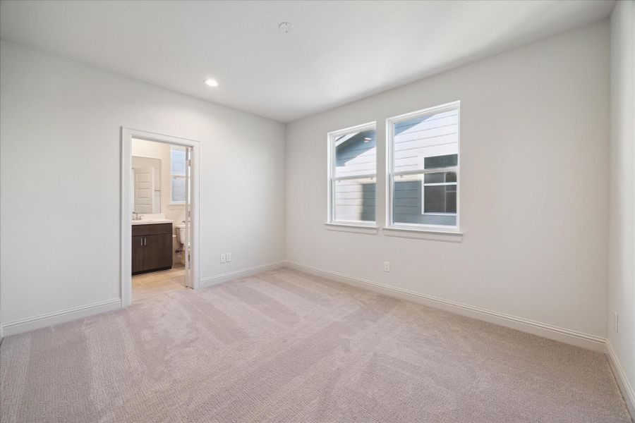 Secondary bedroom on the third floor provides ample natural light and a cozy atmosphere. With neutral tones and plush carpeting, the space offers a blank canvas for customization, whether used as a bedroom, guest room, or home office. Generous closet space and proximity to the primary bedroom makes it both functional and comfortable.