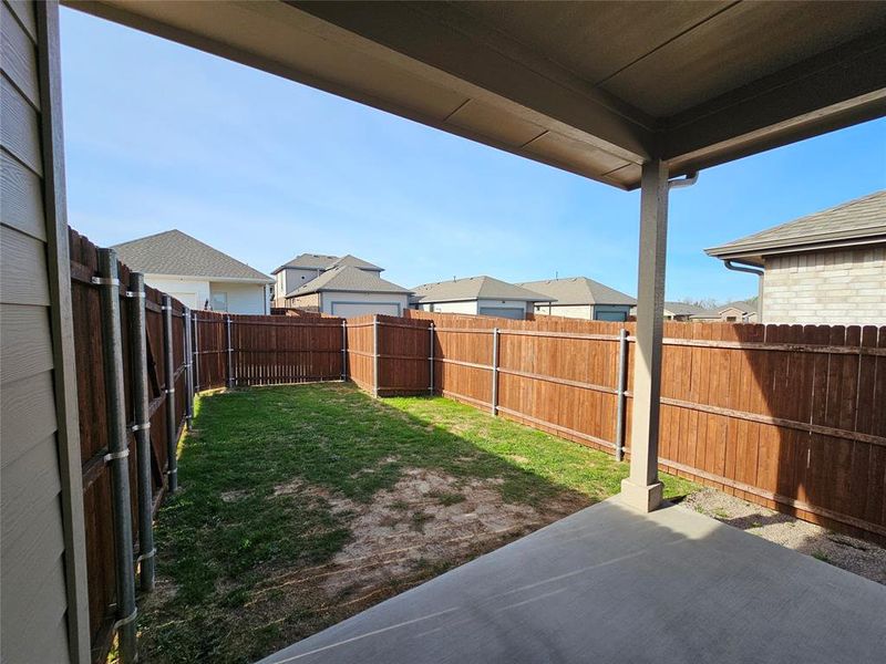 Fenced backyard with a patio area and a residential view