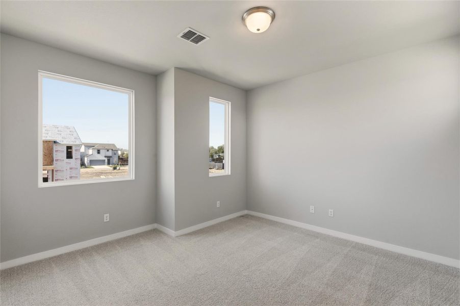 Unfurnished room featuring light carpet and baseboards