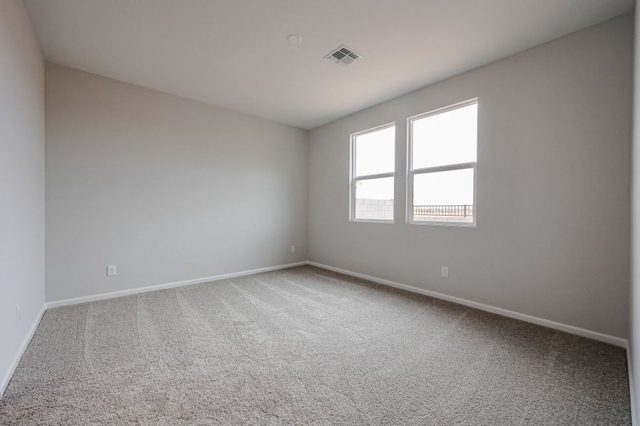 A room with a carpet and windows.