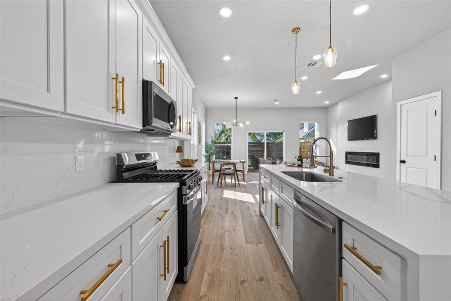 Additional kitchen perspective emphasizing high-end stainless steel appliances, generous counter space, and seamless flow to the dining area and outdoor access, ideal for indoor-outdoor entertaining.