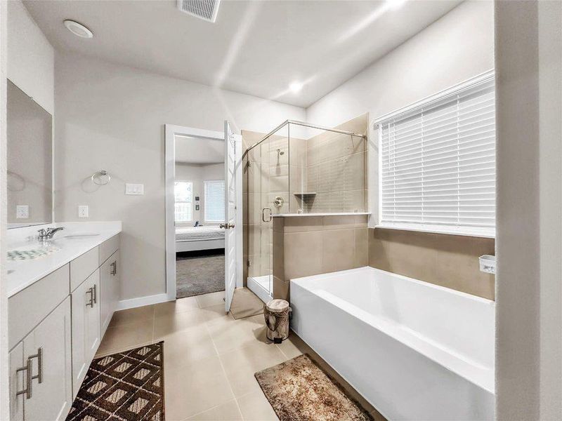 Spa-inspired en-suite bathroom with dual vanities, modern fixtures, and a walk-in shower for comfort and convenience.