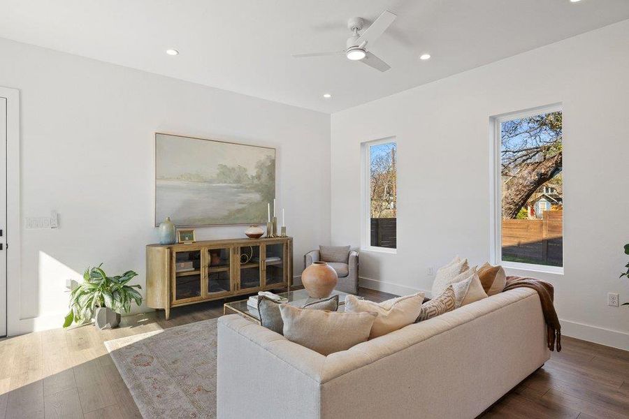 Living area with recessed lighting, wood finished floors, and ceiling fan