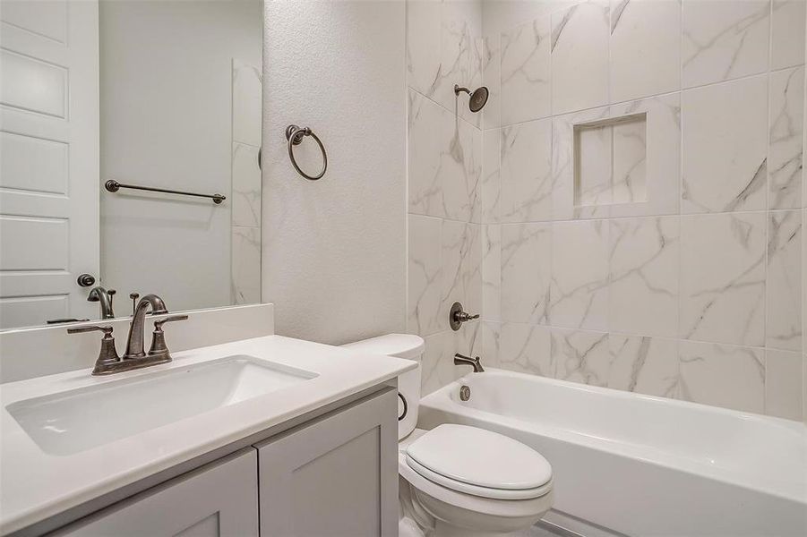 Full bathroom with tiled shower / bath, toilet, and vanity