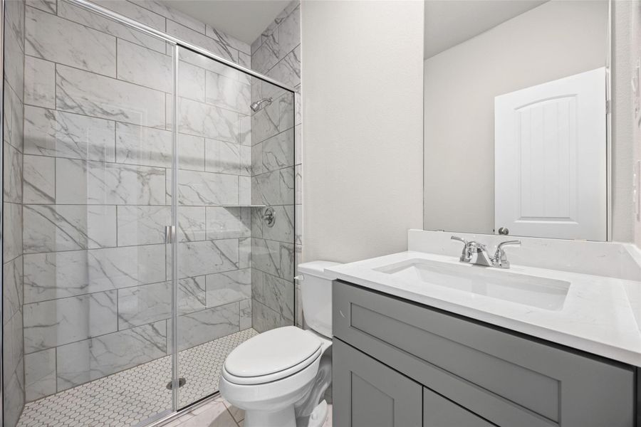 An elegant tile shower and clean vanity define this modern bathroom space. An elegant tile shower and clean vanity define this modern bathroom space.
