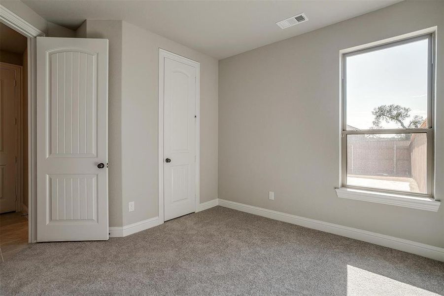 Unfurnished bedroom with light carpet and a closet