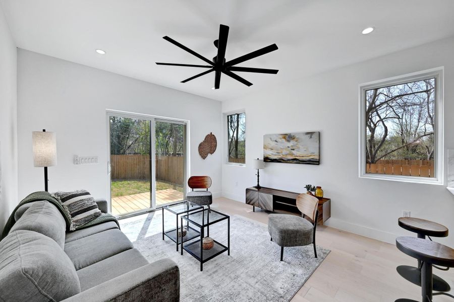 Living room with recessed lighting, a ceiling fan, baseboards, and light wood finished floors