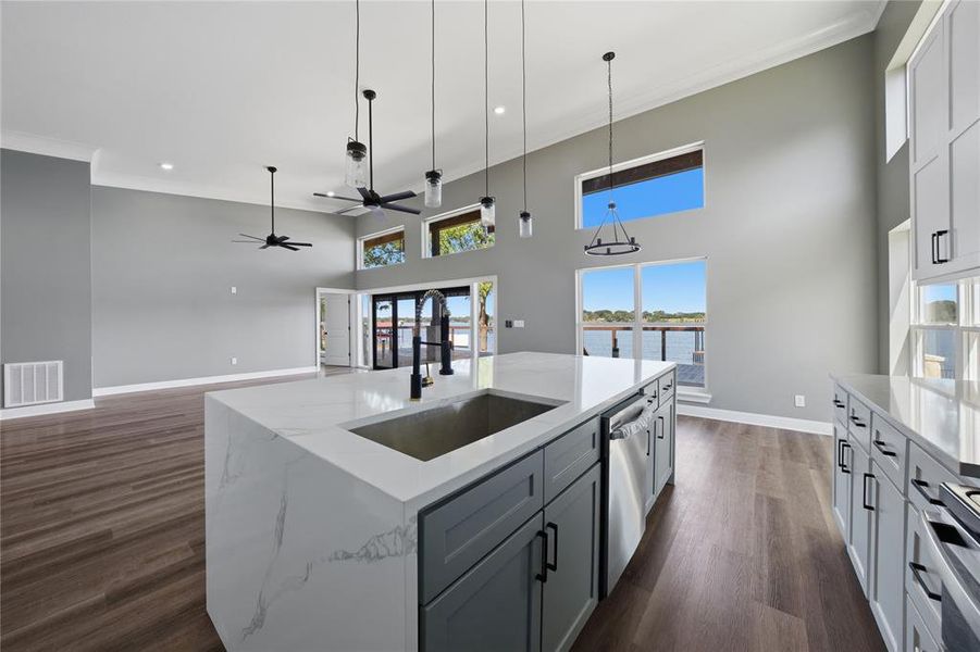 Island kitchen with breakfast bar, walk in pantry and stainless steel appliances.