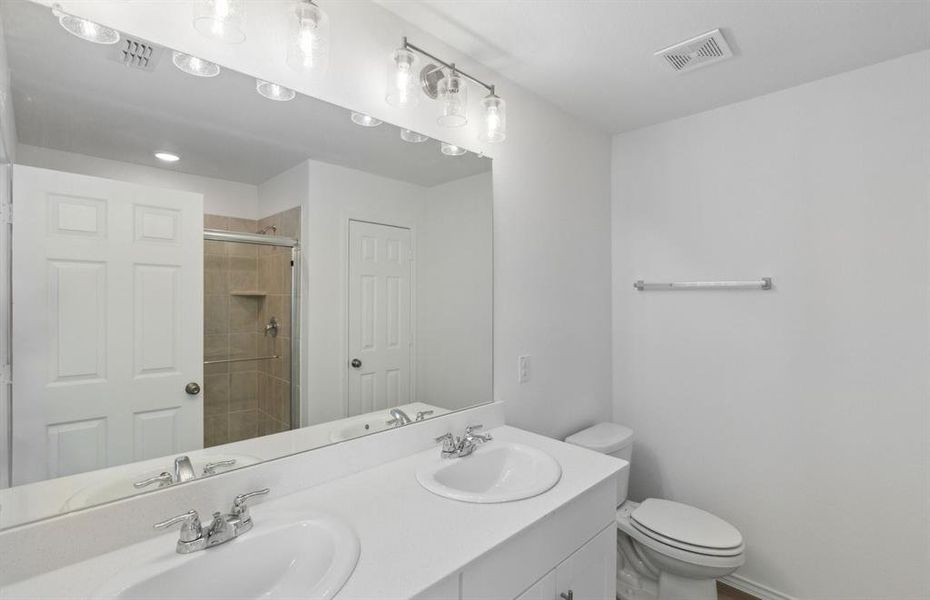 Elegant owner's bathroom with dual vanity *real home pictured