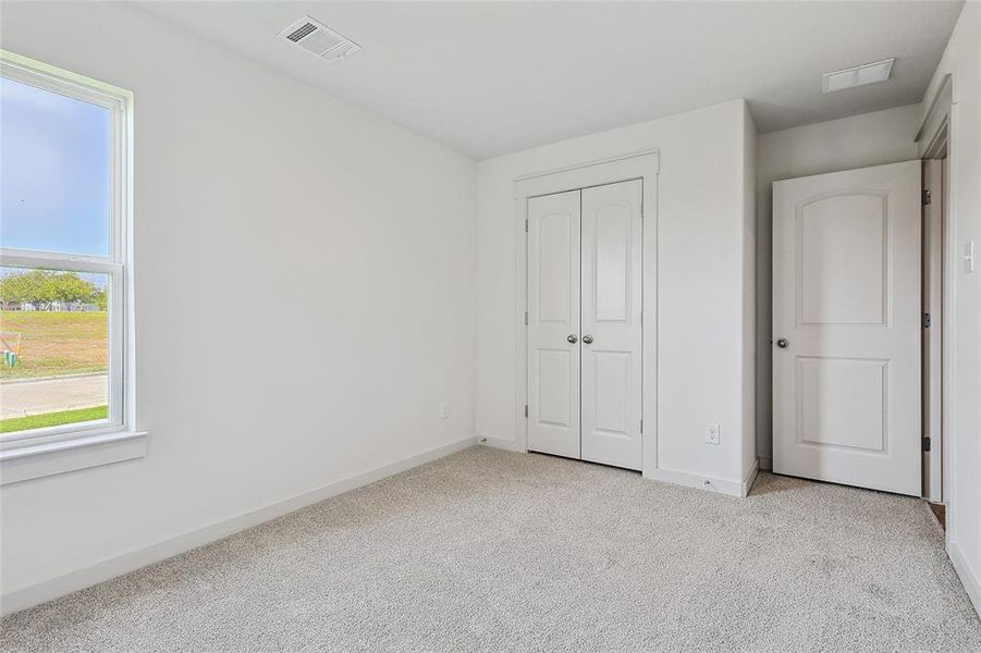 Unfurnished bedroom featuring light colored carpet and a closet