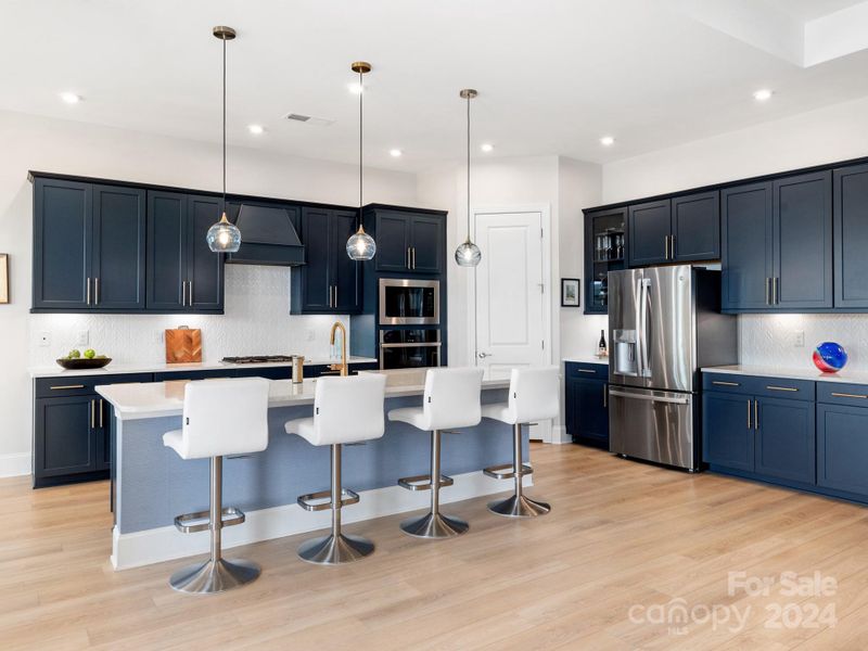 "Moody Blue" cabinets, white Quartz countertops, HAND-BLOWN BicycleGlass light fixtures