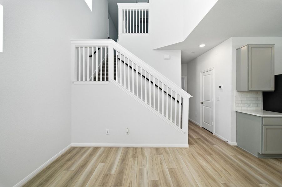 Staircase with wood finished floors and recessed lighting