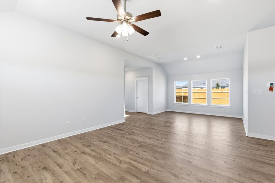 Empty room with vaulted ceiling, wood finished floors, recessed lighting, and ceiling fan