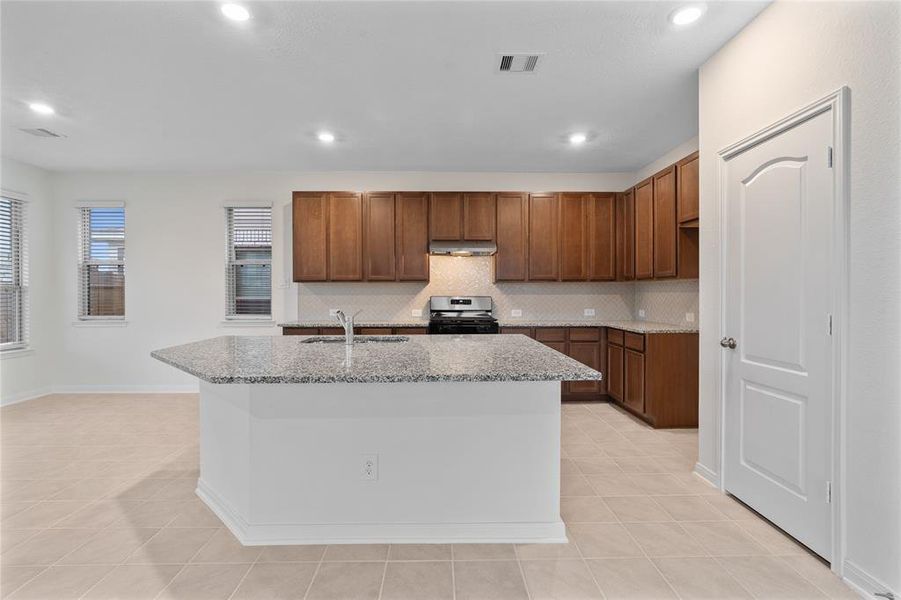 This kitchen is by far any chef’s dream! This spacious kitchen features high ceilings, wood cabinets, granite countertops, SS appliances, modern tile backsplash, recessed lighting, extended counter space, granite kitchen island with double sink and space for breakfast bar, and a walk-in pantry all overlooking your huge family room.