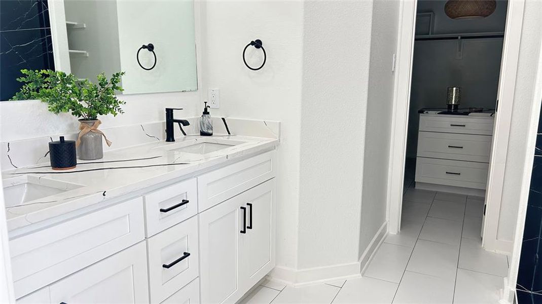 Bathroom with double vanity and tile patterned flooring