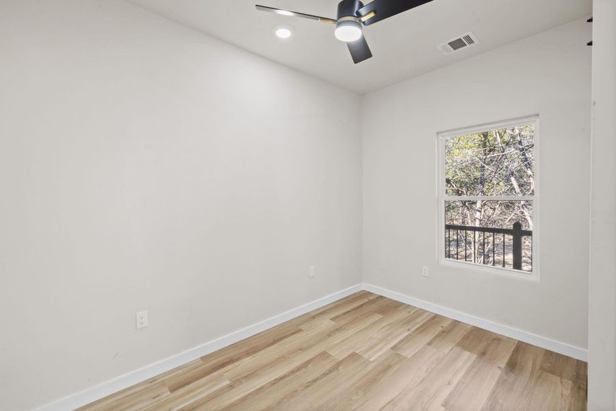 Spare room with light wood-style flooring, ceiling fan, and recessed lighting Spare room with light wood-style flooring, ceiling fan, and recessed lighting