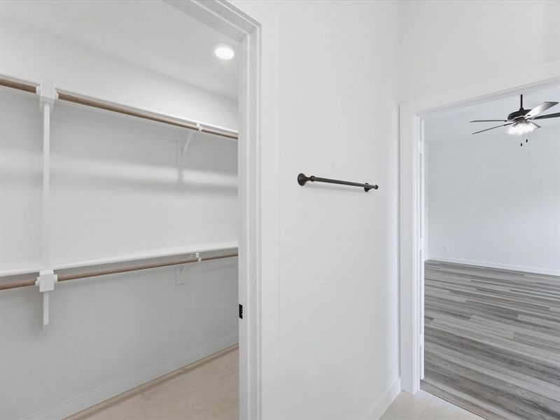 Spacious closet featuring multiple hanging rods and shelving, recessed lighting, and light-toned flooring Spacious closet featuring multiple hanging rods and shelving, recessed lighting, and light-toned flooring