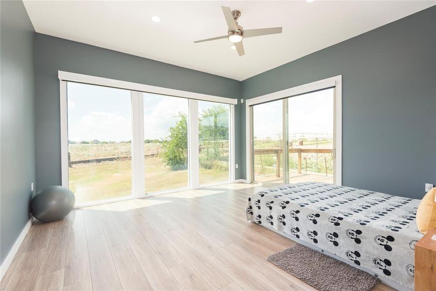 Bedroom featuring light wood-type flooring, ceiling fan, recessed lighting, and access to outside Bedroom featuring light wood-type flooring, ceiling fan, recessed lighting, and access to outside