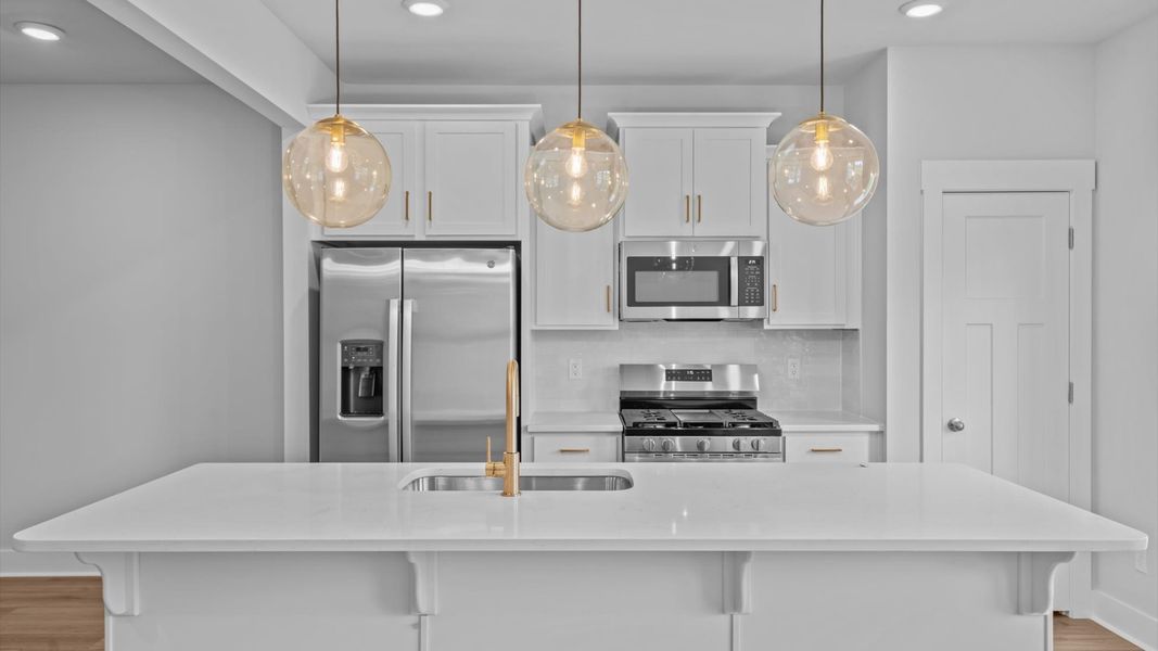 Highly skilled craftsmanship shines in this modern kitchen with pendant lighting and a central island focal point Highly skilled craftsmanship shines in this modern kitchen with pendant lighting and a central island focal point
