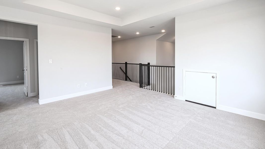 Unfurnished room featuring light carpet, recessed lighting, and a tray ceiling