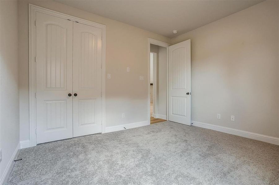 Unfurnished bedroom featuring carpet and a closet