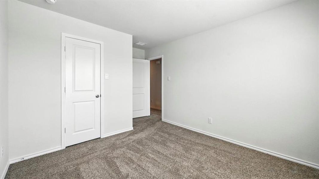 Neutral-toned wall-to-wall carpeting complements clean white walls