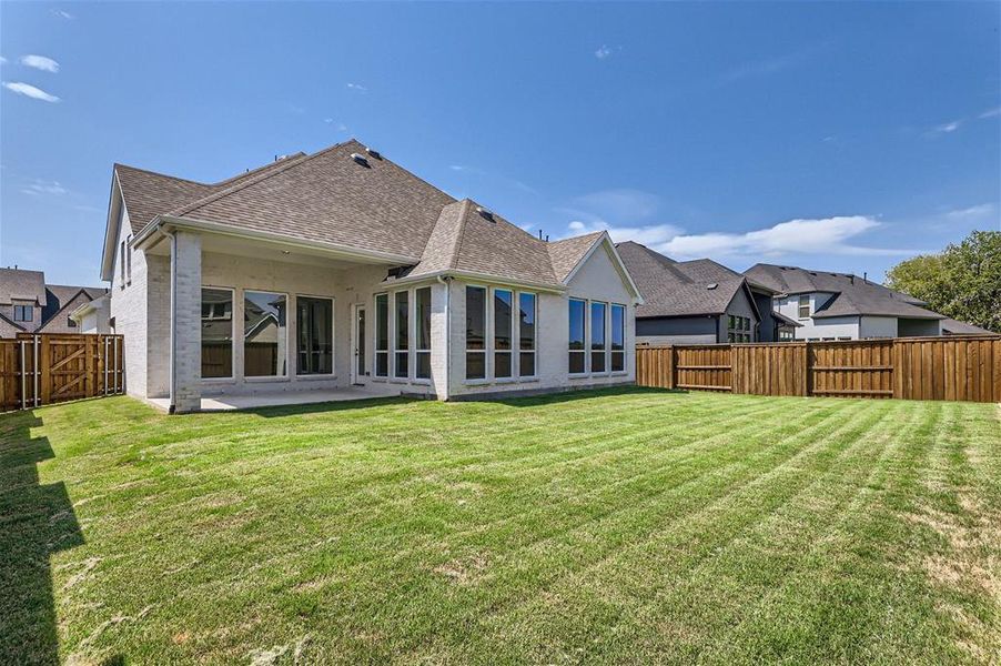 Back of property with a patio and a lawn