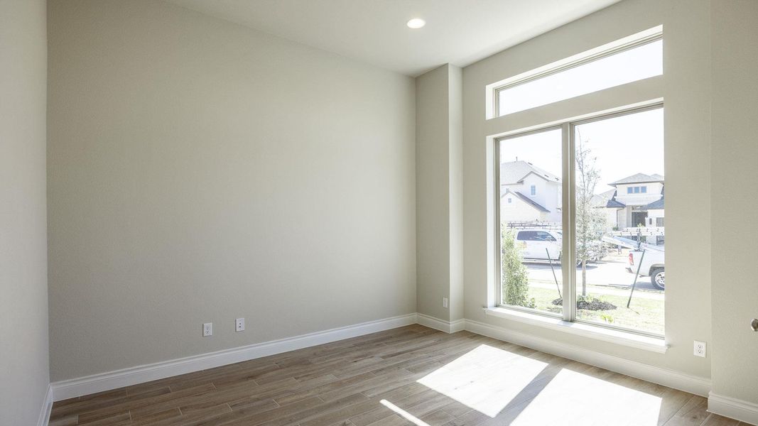 Spare room featuring baseboards, a wealth of natural light, and wood finished floors Spare room featuring baseboards, a wealth of natural light, and wood finished floors