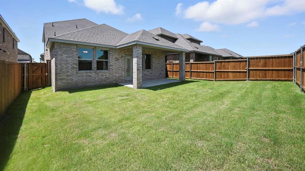 Back of property with brick siding, a gate, a patio, a shingled roof, and a fenced backyard Back of property with brick siding, a gate, a patio, a shingled roof, and a fenced backyard