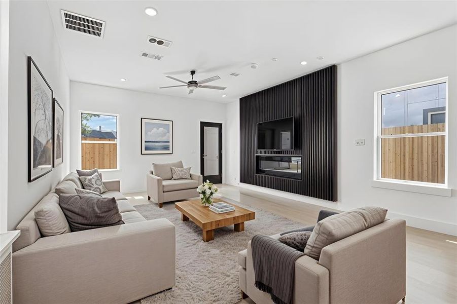 Spacious living area featuring a striking black slatted accent wall with integrated media console and fireplace