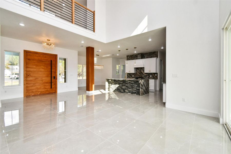 A chef’s dream, featuring high-end cabinetry, stone countertops, and a waterfall island. The open layout ensures the cook is always part of the conversation in the adjacent dining area.