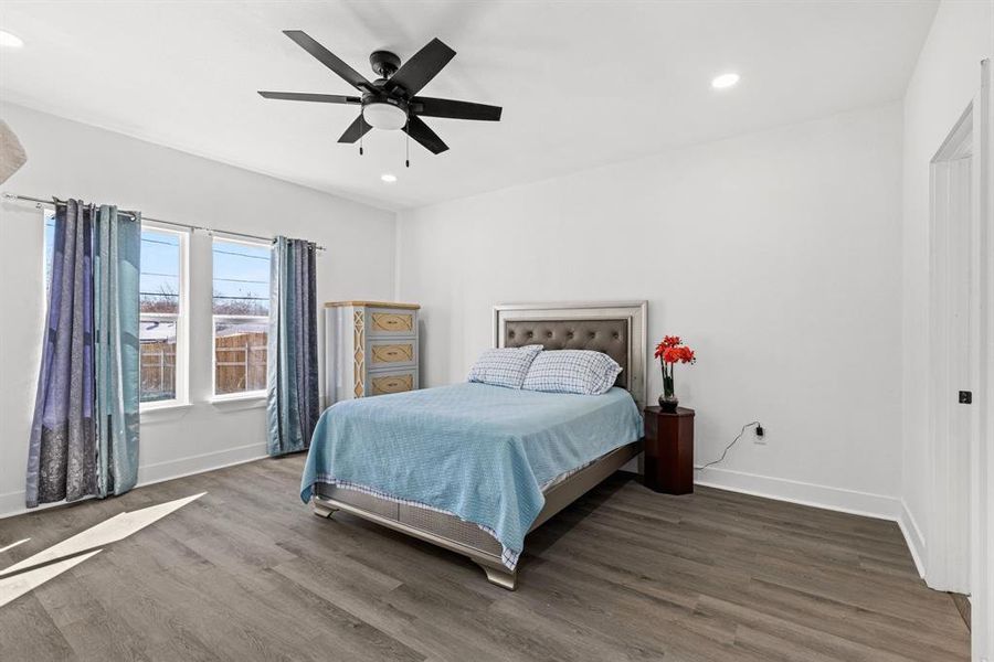 Bedroom with dark hardwood / wood-style flooring and ceiling fan