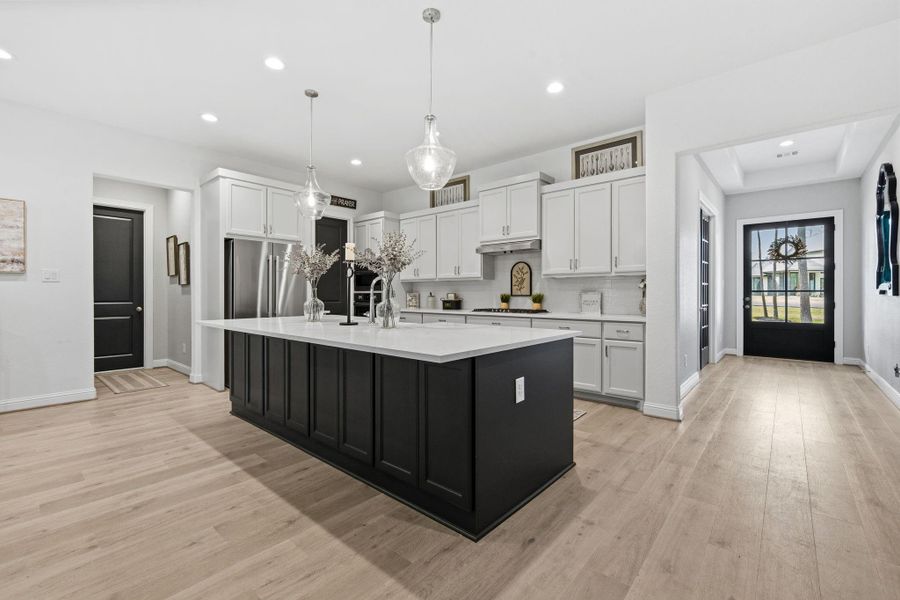 This island was upgraded to a larger size to accommodate for more cabinetry in the back for more storage and seating.