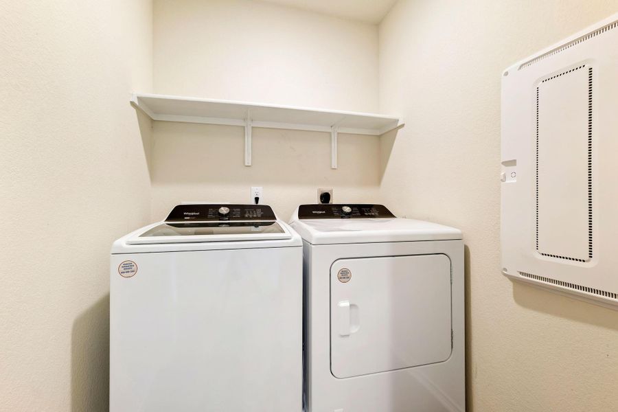 A well-equipped laundry space with essential appliances and convenient shelving. A well-equipped laundry space with essential appliances and convenient shelving.