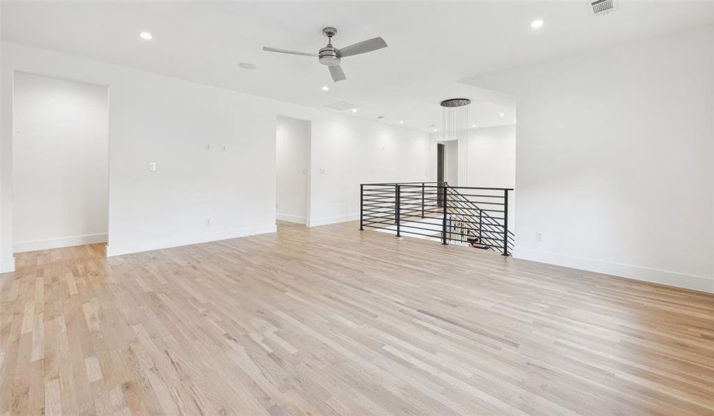 Unfurnished living room featuring ceiling fan and light wood-type flooring