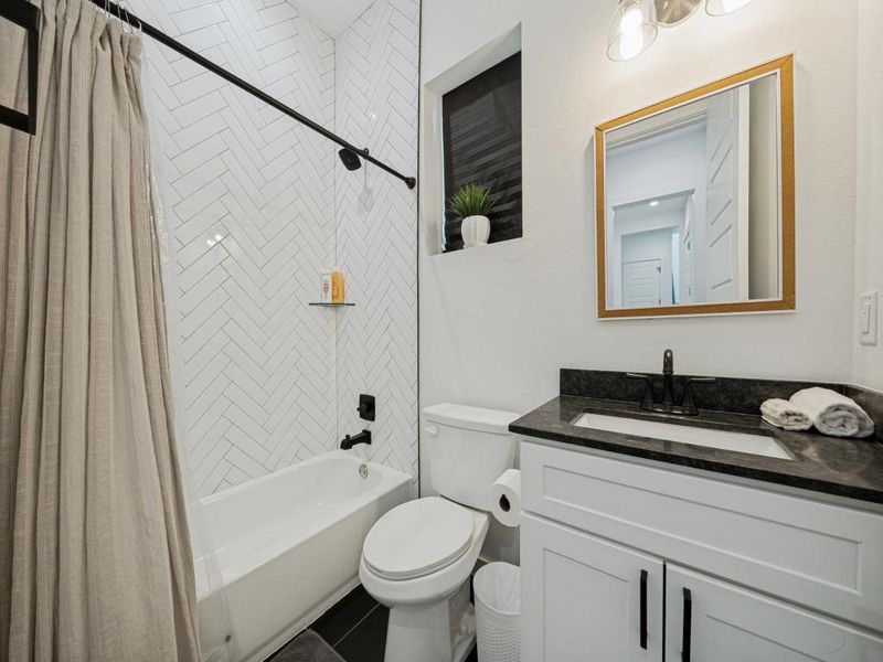 A well-appointed bathroom features a bathtub and a vanity with sleek granite counters. A well-appointed bathroom features a bathtub and a vanity with sleek granite counters.