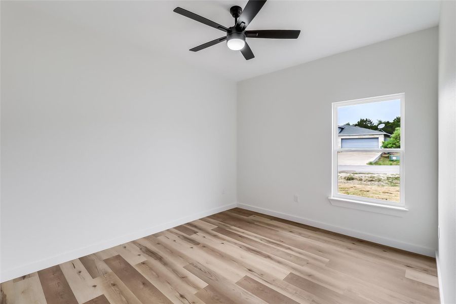 Empty room with baseboards, a ceiling fan, and light wood finished floors