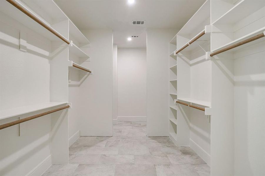 Massive owner's closet with tile floors, LED lighting, hang bars, shoe accessory and shoe storage and nook for your Safe, shelter, vanity or extra storage.